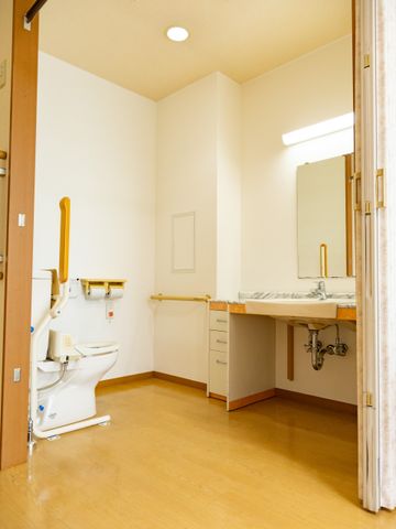 清潔感あるトイレ空間 洗面台 手すり付きのトイレと、使いやすい高さの洗面台が配置された明るい空間です。安心してお使いいただける設計になっています。
