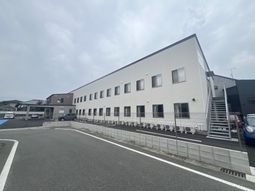 白い壁の建物と駐車場
