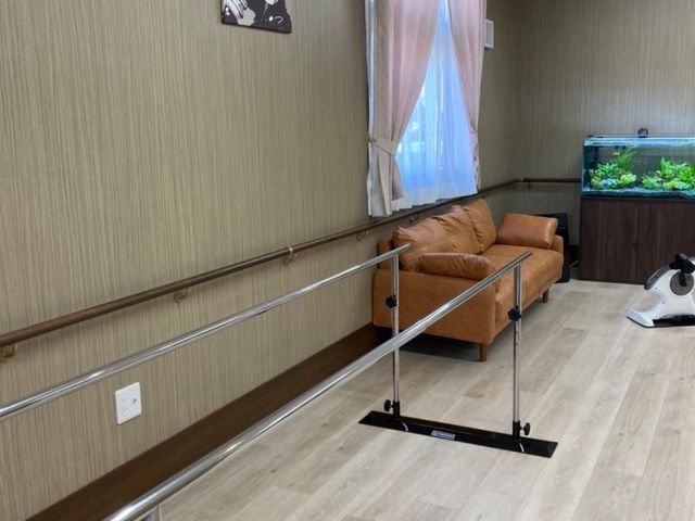 温かみのある廊下 平行棒 廊下には手すりが備え付けられ、壁にはアートが飾られた快適なスペースが広がっており、居心地の良さを感じられます。