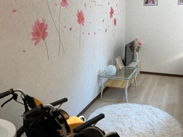 花柄壁の居室内 居室 ゆったりとした車椅子対応の居室です。壁には優しい花のデザインがあり、温かい雰囲気でお過ごしいただけます。