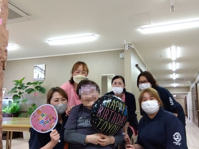 スタッフのお祝い様子 お誕生日イベント 笑顔あふれるスタッフが集う温かな場面です。ケアをする側もされる側も、日々の生活の中で特別な瞬間を共に祝える環境があります。