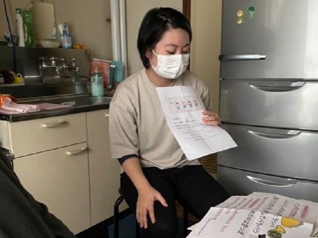 資料を読むスタッフ スタッフイメージ スタッフが資料を用いて、お客様に丁寧に説明をしています。理解を深めるためのサポートを実施中です。