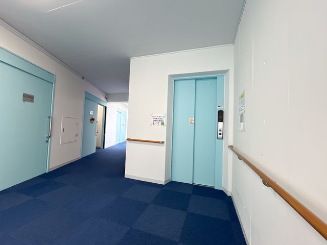 明るい廊下の風景 廊下 手すりが付いた廊下は清潔感があり、柔らかな色合いで落ち着いた雰囲気を醸し出しています。