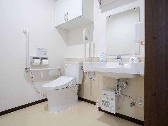 バリアフリー設計の洗面トイレ トイレ 手すり付きで安全性を考慮したトイレと洗面所。清潔感のあるこの空間は、日々の快適な生活を支えます。