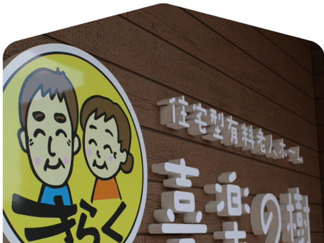看板の木壁 看板   木目の壁に、やさしい雰囲気のロゴと施設名が掲げられています。来訪時に目印になりやすい外観まわりです。