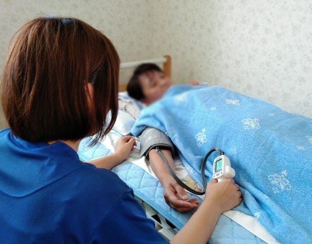 居室にてバイタル確認 居室 居室では、健康状態の確認が行われています。温かみのある空間で安心して過ごせます。