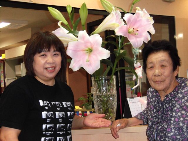 スタッフと利用者の笑顔 リビング 笑顔のスタッフが、居心地の良いリビングで利用者と楽しい時を過ごしています。