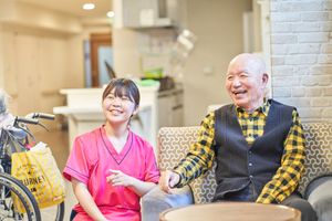 笑顔のスタッフと男性の居室