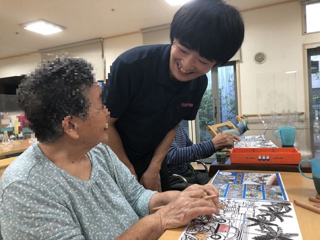 和やかな機能訓練室 機能訓練室 笑顔で接するスタッフと共に、心地よい機能訓練の時間を過ごされている様子です。安心して日々をお過ごしいただける空間です。