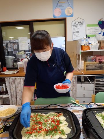 手作り料理を提供する様子 料理 マスクと手袋をしたスタッフが、手作りの料理をていねいに提供している様子です。安心してお食事をお楽しみいただけます。