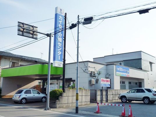 施設外観の看板前  