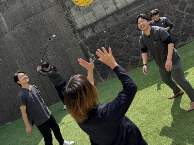 楽しげな人々の様子　庭 庭 自然光の下、笑顔で交流するスタッフたち。明るく開放的な環境が魅力です。