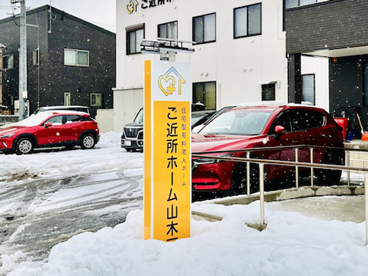 雪の外観と看板のある入口  