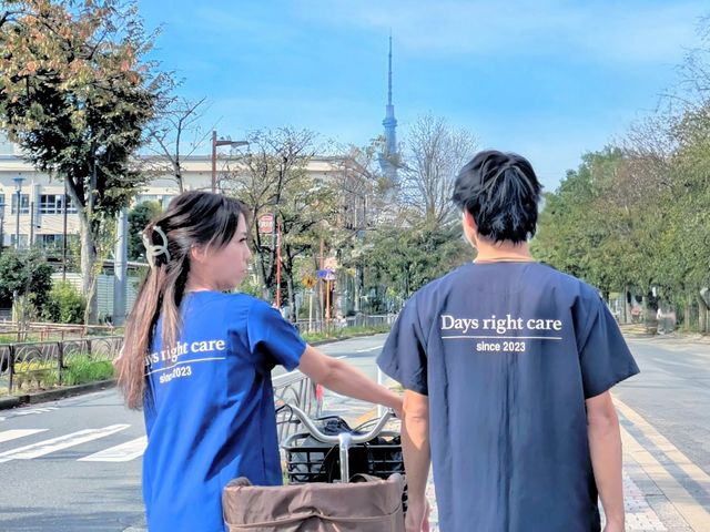 施設周辺の風景 スタッフイメージ 青空の下で職員が共に歩いています。施設近くの景色を感じることができます。