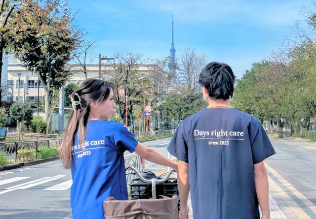 施設周辺の風景 スタッフイメージ 青空の下で職員が共に歩いています。施設近くの景色を感じることができます。
