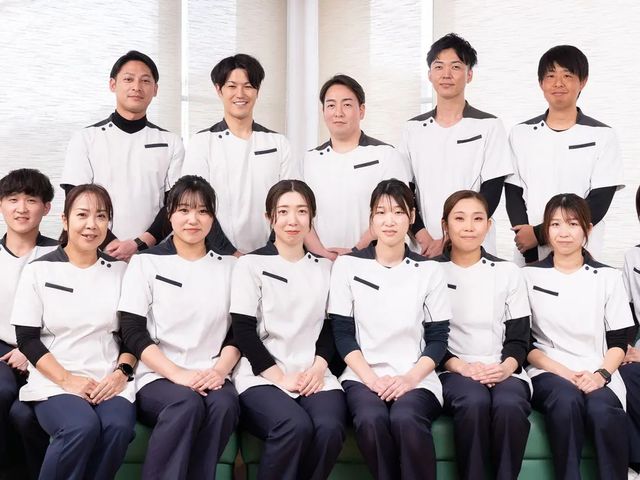 スタッフ集合の様子 スタッフイメージ   白いユニフォームを着たスタッフが並んでおり、落ち着いた雰囲気で連携の良さが伝わります。明るく清潔感のある職場を考えている方に向いています。