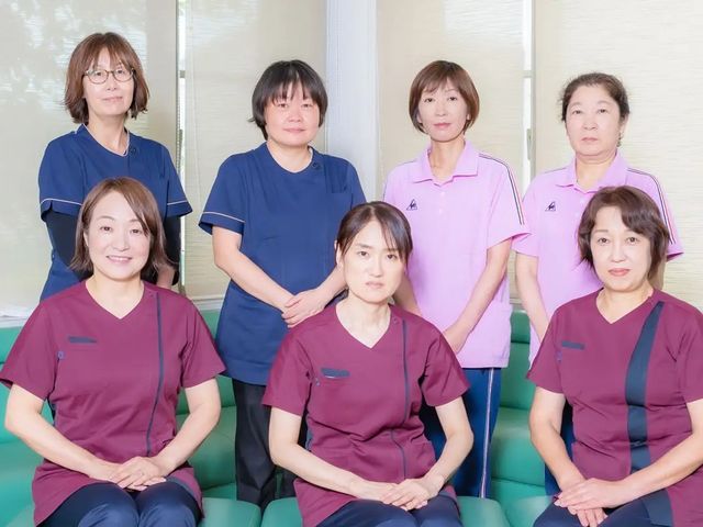 スタッフ集合のリビング リビング   落ち着いた色合いのユニフォームを着たスタッフの皆さんが並んでいます。連携して働く雰囲気が伝わり、就業後のイメージを持ちやすいです。