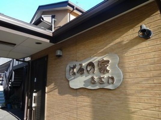 木目外壁の看板がある外観  
