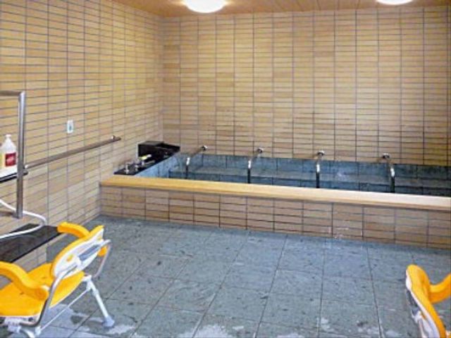 清潔な浴室の全景 浴室 広々とした快適な浴室で、ゆったりと寛げる環境です。手すりや座るための椅子も完備され、安心してお使いいただけます。