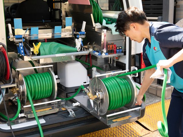 男性と機能訓練室 丁寧な仕事をしている男性スタッフがいます。機器の操作にも慣れており、安心して業務に就くことができそうです。