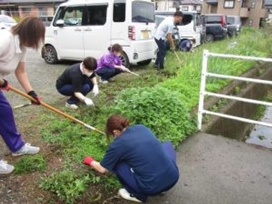庭で草むしりするスタッフ  
