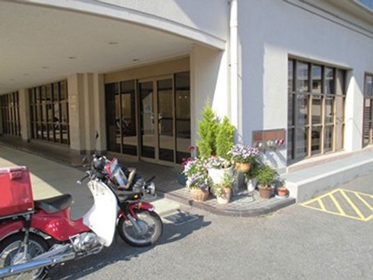 出入口前のバイクと植木の外観  