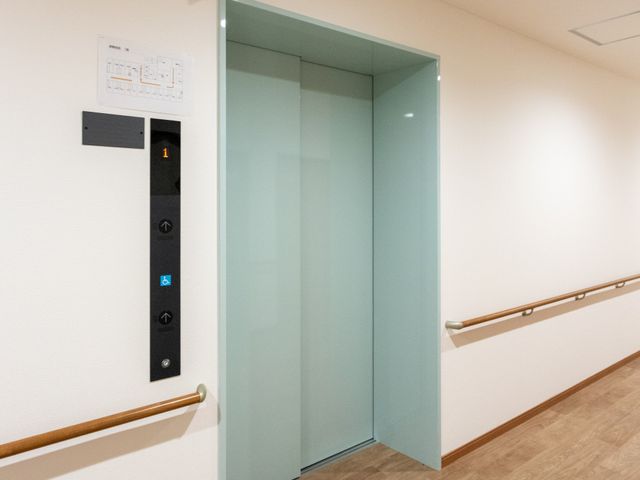 明るい廊下のエレベーター エレベーター 手すりが設置された清潔感のある廊下に、車椅子でも安心して利用できるエレベーターが備わっています。