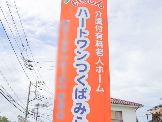 オレンジ色の明るい看板 看板 暖かみのあるデザインの看板が立っていて、周囲の環境との調和も感じられます。安心感を与える色使いが印象的です。
