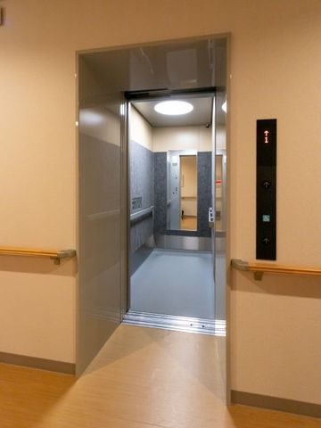 開いた状態のエレベーター エレベーター 私たちの施設では、スタッフの移動の効率を高める現代的なエレベーターが整っています。