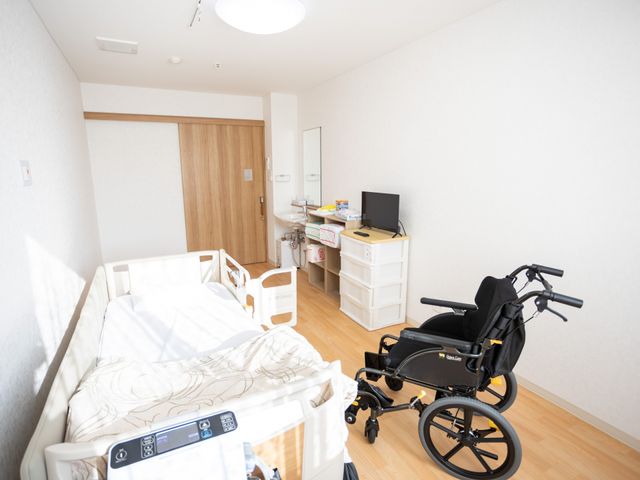 広々とした居室 居室 自然光が差し込み、ベッドや車椅子が配置された快適な空間です。働きやすい環境が魅力です。