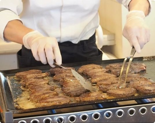 ステーキ調理中の職員