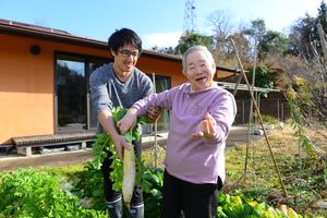笑顔で野菜を収穫する人々