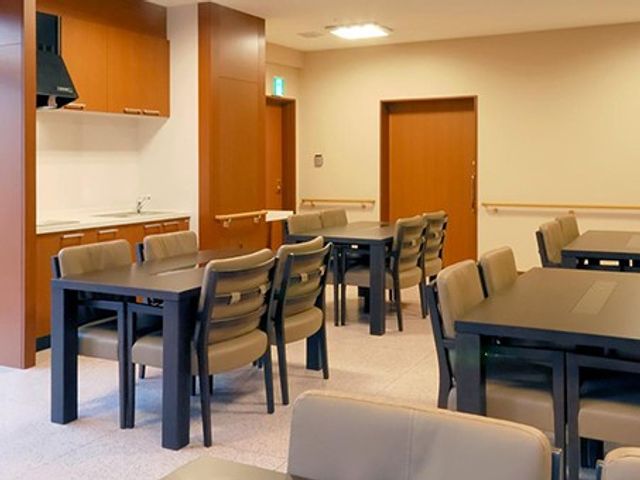 食堂テーブルが並ぶ食堂 食堂   ゆとりのあるテーブル配置で、落ち着いて食事ができそうな空間です。木目調の扉や収納があり、あたたかみのある雰囲気です。