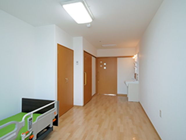 明るく広々とした居室 居室２ 清潔感溢れる居室は、明るい自然光が差し込む落ち着いた空間です。ベッド周りには動きやすい配慮がされており、快適にお過ごしいただけます。