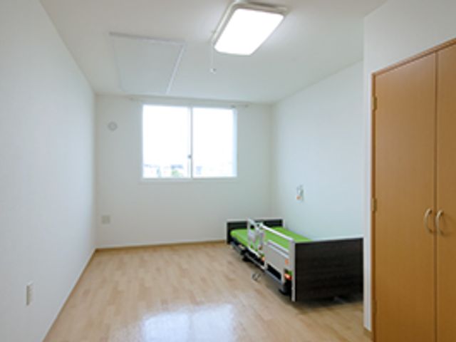 広々とした明るい居室 居室１ ゆとりのある空間の居室です。日当たりのよい窓辺には、心地良い休息が得られるベッドが設置してあります。