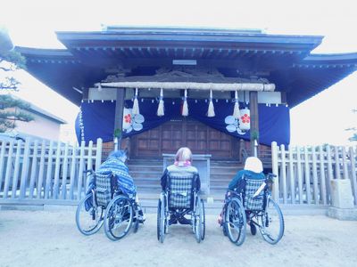 和風建築前の車椅子の方々