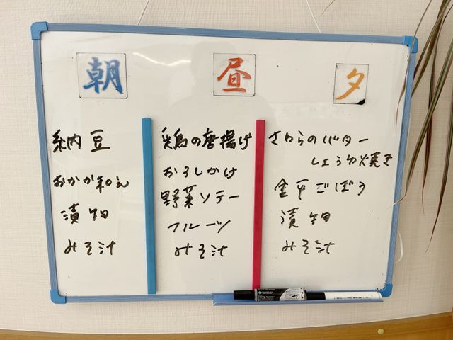 白板に書かれた日程表 掲示物 毎日の予定が書かれた白板です。見やすく整理された内容で、日々の活動が一目で分かります。