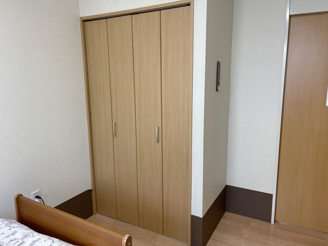 ゆったりとした居室の風景 居室 木目調の扉が印象的な居室です。ベッドからも手が届きやすく、日々の生活が快適に過ごせる配慮がされています。