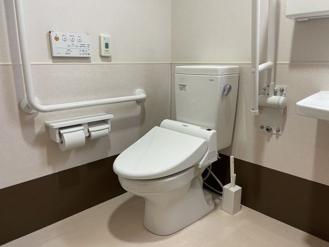 バリアフリー設計のトイレ トイレ 手すり付きで安全に配慮された清潔感のあるトイレです。日々の生活に安心を提供します。