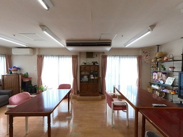 ゆったりした居室 共有スペース ゆったりと配置されたテーブルや椅子がある居室です。窓からの光で明るく、快適な時間を過ごせる空間です。