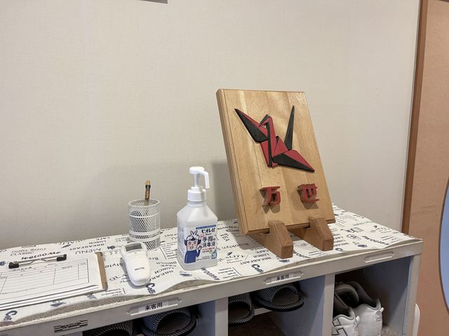 アート作品と備品の机 エントランス 手作り感あふれるアート作品が置かれ、個性的な空間の一角を演出しています。アートに触れながらの寛ぎ時間を楽しめます。