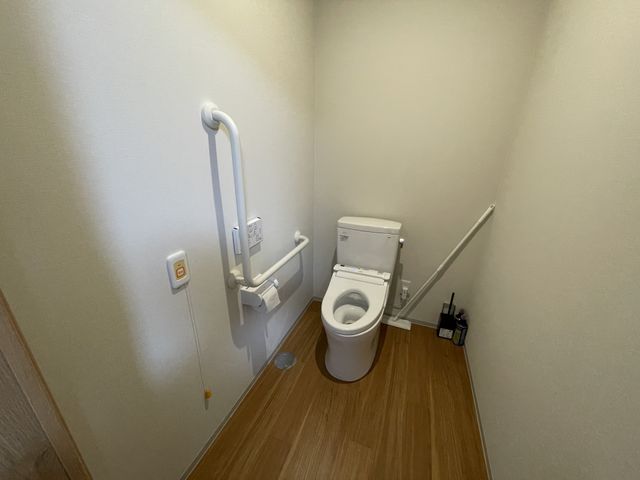 手すり付きの清潔なトイレ トイレ 安全なサポートが考えられた手すり付きのトイレです。静かで落ち着いた色合いが心地良い空間を演出しています。