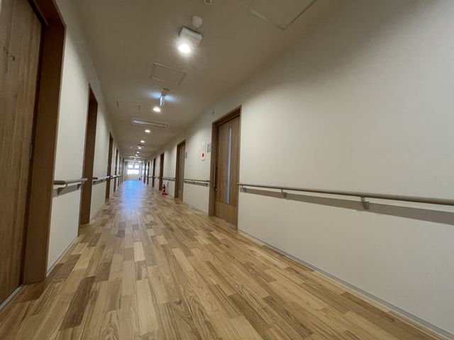 手すり付きの明るい廊下 廊下 ゆったりとした手すりが設置された廊下です。安全に歩行できる環境が整っており、安心してお過ごしいただけます。