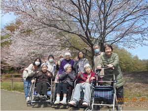桜と共に笑顔のスタッフ