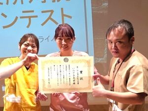 表彰状を持つ3人のスタッフ