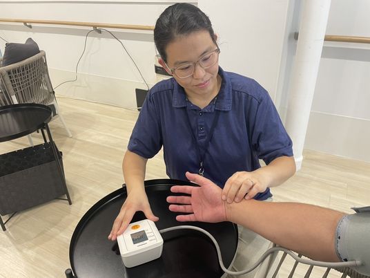 腕に触れる職員