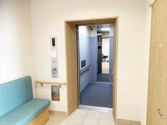 温かみのあるエレベーター エレベーター エレベーター前には、柔らかな色合いのベンチが設置され、居心地の良い空間になっています。