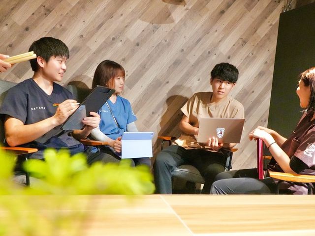 会話する人々の居室 居室 ゆったりとした居室で、何人かが和やかに会話を楽しんでいます。円滑なコミュニケーションを促す環境が整っています。