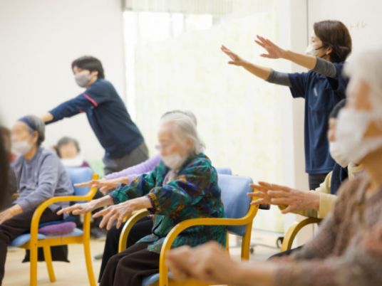 座って体操する人々