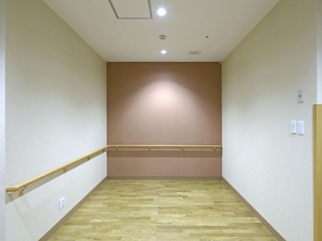 廊下の手すり付き通路 廊下 明るくすっきりした通路で、両側に手すりが設けられています。移動しやすさに配慮されたつくりに見えます。